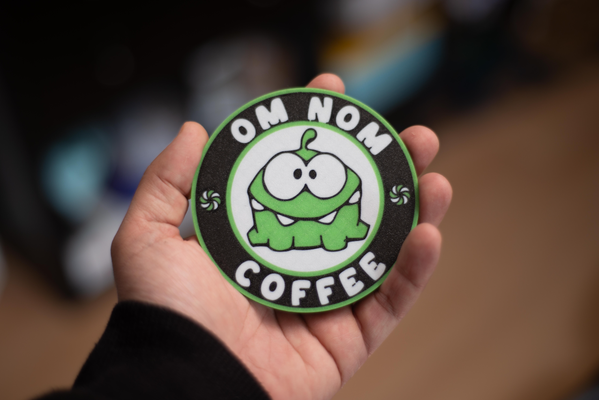 om nom coaster by gb household decor funny green game white black coffee beer beverage table protection holder cut rope 3d print model - Mito3D